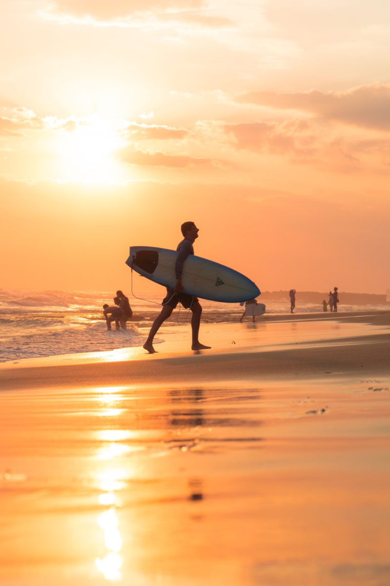 Surfen op Bali met zonsondergang.